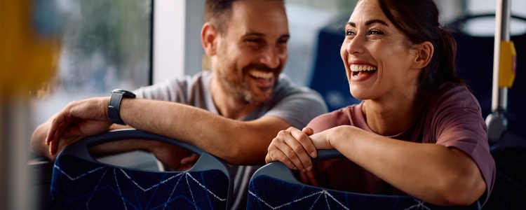 Two smiling passengers on a charter bus
